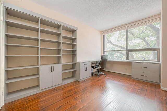 5150 Hidalgo St Unit 204, Houston, TX 77056 - office area with built in study area, a textured ceiling, healthy amount of natural light, and wood finished floors