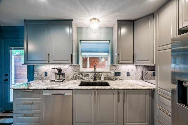 4019 Grennoch Ln, Houston, TX 77025 - kitchen featuring gray cabinets, appliances with stainless steel finishes, tasteful backsplash, and a textured ceiling