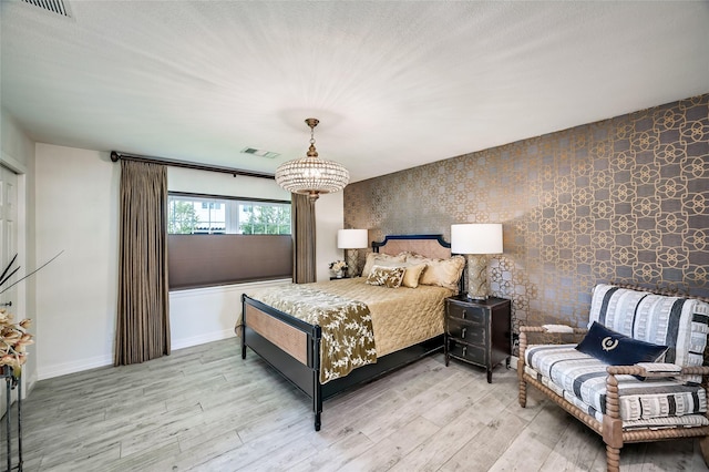 4019 Grennoch Ln, Houston, TX 77025 - bedroom with an accent wall, a chandelier, and light wood-type flooring
