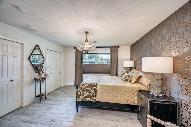 4019 Grennoch Ln, Houston, TX 77025 - bedroom with wood finished floors, two closets, and a chandelier