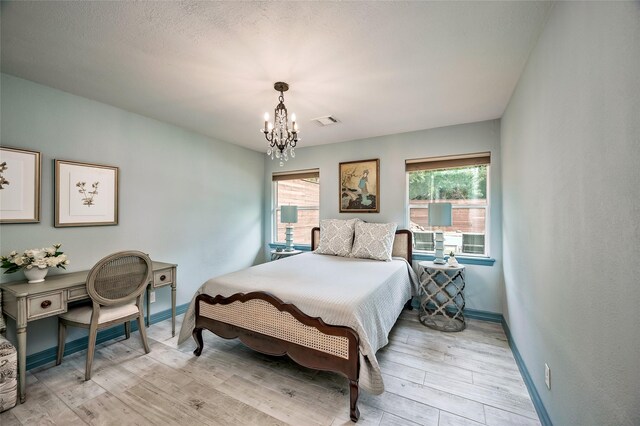 4019 Grennoch Ln, Houston, TX 77025 - bedroom featuring a chandelier, multiple windows, and light wood-type flooring