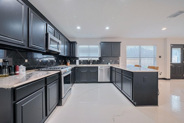 13703 Broad Oaks Ln, Rosharon, TX 77583 - kitchen featuring stainless steel appliances, a peninsula, recessed lighting, backsplash, and light stone countertops