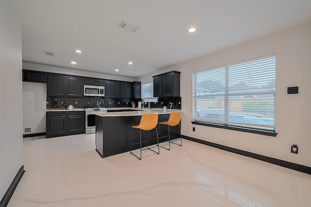13703 Broad Oaks Ln, Rosharon, TX 77583 - kitchen with stainless steel appliances, dark cabinets, decorative backsplash, recessed lighting, and a peninsula