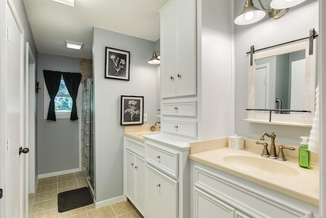 105 Pleasant Valley Dr, West Columbia, TX 77486 - bathroom with two vanities, a shower stall, tile patterned floors, and a textured ceiling