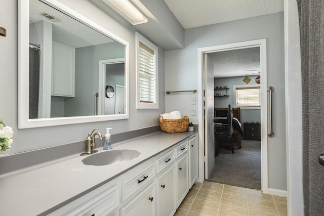 105 Pleasant Valley Dr, West Columbia, TX 77486 - ensuite bathroom featuring a textured ceiling, vanity, and tile patterned floors