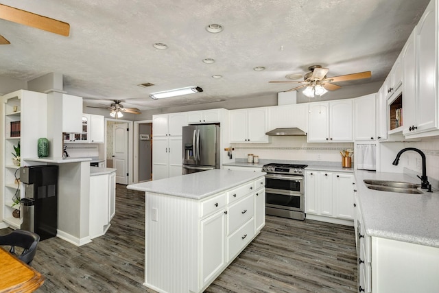 105 Pleasant Valley Dr, West Columbia, TX 77486 - kitchen with stainless steel appliances, a ceiling fan, dark wood-type flooring, a kitchen island, and white cabinetry
