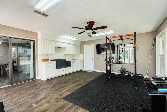 105 Pleasant Valley Dr, West Columbia, TX 77486 - exercise area featuring a ceiling fan, dark wood-style floors, and a textured ceiling
