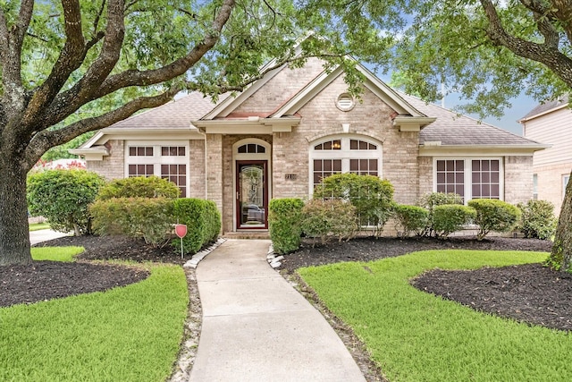 7110 Timber Post Ln, Humble, TX 77346 - view of front of house with a shingled roof, brick siding, and a front yard