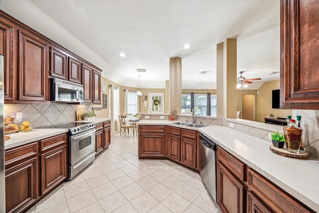 7110 Timber Post Ln, Humble, TX 77346 - kitchen with appliances with stainless steel finishes, light countertops, decorative backsplash, light tile patterned floors, and pendant lighting