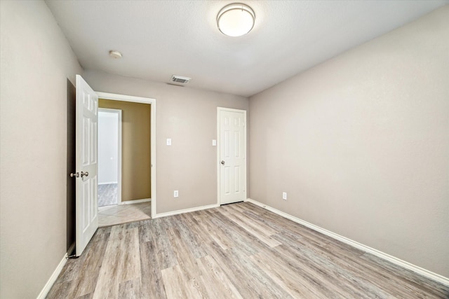 7110 Timber Post Ln, Humble, TX 77346 - unfurnished bedroom featuring light wood finished floors and baseboards