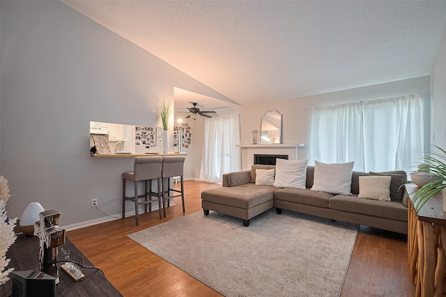 700 Thicket Ln Unit 306, Houston, TX 77079 - living area featuring a ceiling fan, wood finished floors, vaulted ceiling, and a tiled fireplace