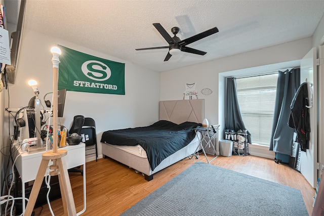700 Thicket Ln Unit 306, Houston, TX 77079 - bedroom with a textured ceiling, wood finished floors, and a ceiling fan