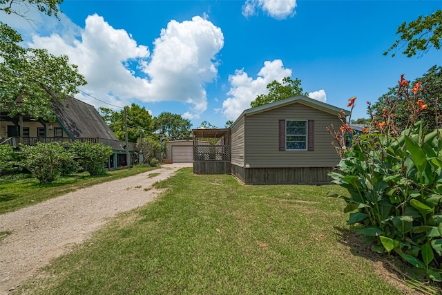 232 3rd St, Dickinson, TX 77539 - view of side of home featuring driveway, an outbuilding, a lawn, and a garage