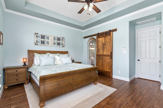 32226 Waterford Crest Ln, Fulshear, TX 77441 - bedroom with a barn door, wood finished floors, a raised ceiling, connected bathroom, and a ceiling fan