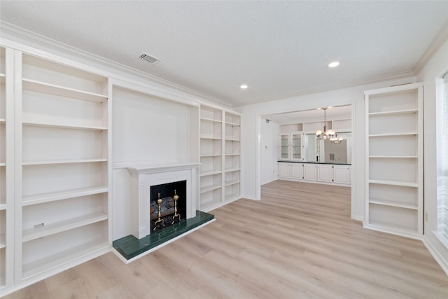 18307 Cransley Dr, Houston, TX 77084 - unfurnished living room with a chandelier, light wood-style floors, crown molding, a fireplace with raised hearth, and a textured ceiling