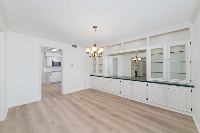 18307 Cransley Dr, Houston, TX 77084 - unfurnished dining area with a chandelier, light wood-style floors, and ornamental molding