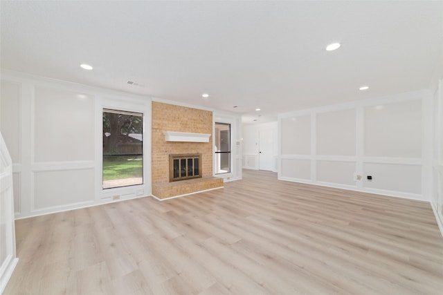 18307 Cransley Dr, Houston, TX 77084 - unfurnished living room with light wood-type flooring, a fireplace, recessed lighting, and crown molding