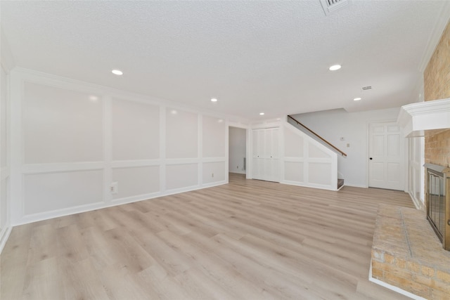 18307 Cransley Dr, Houston, TX 77084 - unfurnished living room with a brick fireplace, stairway, light wood-style flooring, and recessed lighting