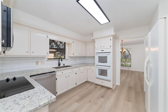 18307 Cransley Dr, Houston, TX 77084 - kitchen featuring white appliances, light wood-style flooring, tasteful backsplash, and plenty of natural light