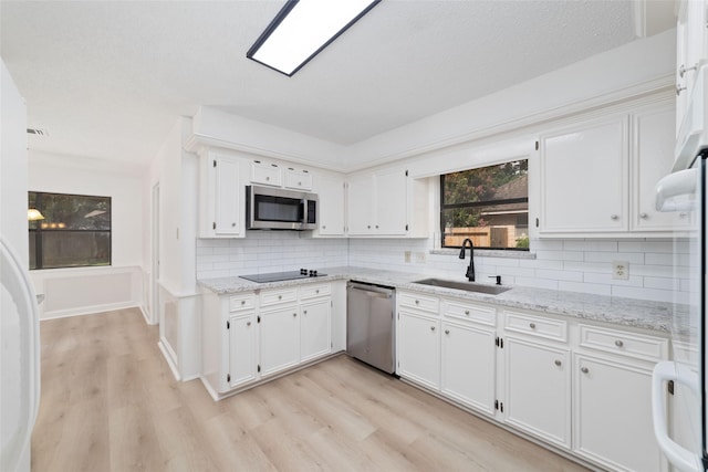 18307 Cransley Dr, Houston, TX 77084 - kitchen with appliances with stainless steel finishes, light wood-style flooring, and white cabinetry