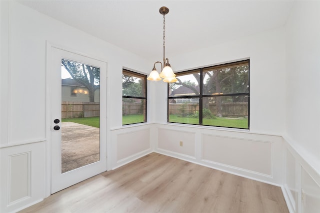 18307 Cransley Dr, Houston, TX 77084 - unfurnished dining area with a decorative wall, a chandelier, light wood-style floors, and a wainscoted wall