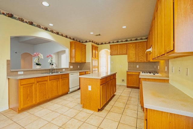 7907 Swan Hollow Ct, Houston, TX 77041 - kitchen featuring white appliances, light countertops, tasteful backsplash, a center island, and arched walkways
