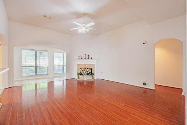 7907 Swan Hollow Ct, Houston, TX 77041 - unfurnished living room featuring arched walkways, ceiling fan, wood finished floors, and a fireplace