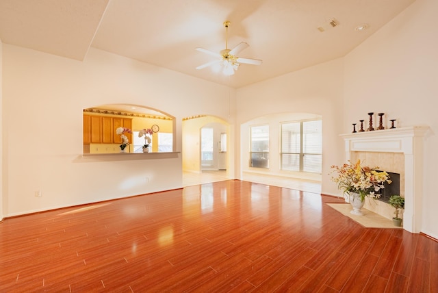 7907 Swan Hollow Ct, Houston, TX 77041 - unfurnished living room featuring ceiling fan, wood finished floors, a tiled fireplace, and lofted ceiling