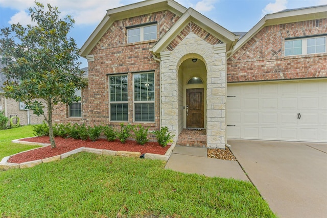 2012 Post Oak Ct, Pearland, TX 77581 - view of front of home with brick siding, a front yard, driveway, an attached garage, and stone siding