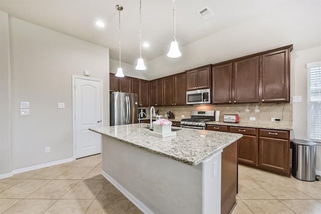 2012 Post Oak Ct, Pearland, TX 77581 - kitchen featuring appliances with stainless steel finishes, tasteful backsplash, light tile patterned floors, light stone counters, and an island with sink