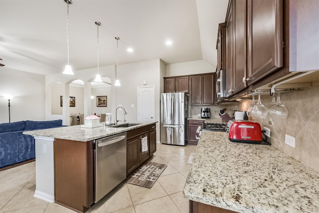 2012 Post Oak Ct, Pearland, TX 77581 - kitchen with stainless steel appliances, light tile patterned floors, open floor plan, arched walkways, and decorative backsplash