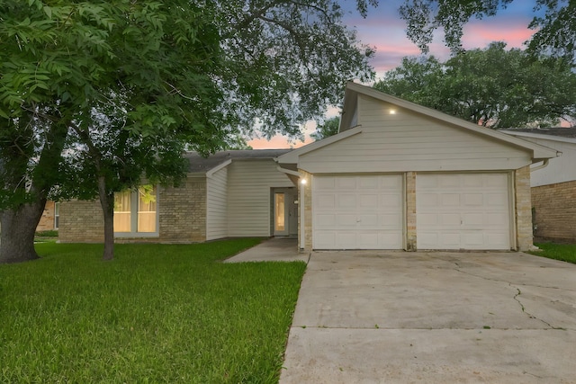 4307 Jura Dr, Houston, TX 77084 - mid-century home with brick siding, an attached garage, concrete driveway, and a lawn