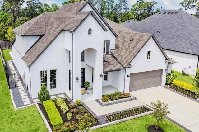 31 Floral Vista Dr, Tomball, TX 77375 - french country home with stucco siding, roof with shingles, and driveway