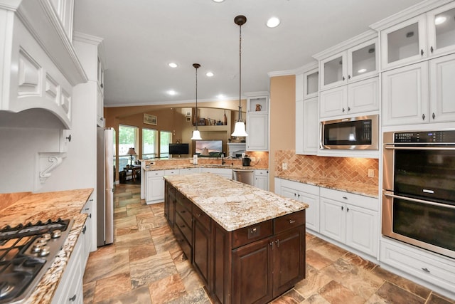 102 Stonecrop Pl, Montgomery, TX 77316 - kitchen with appliances with stainless steel finishes, stone tile flooring, ornamental molding, dark brown cabinets, and white cabinetry