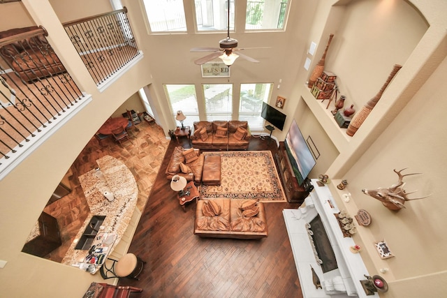 102 Stonecrop Pl, Montgomery, TX 77316 - living room featuring a fireplace, a high ceiling, a ceiling fan, and hardwood / wood-style flooring
