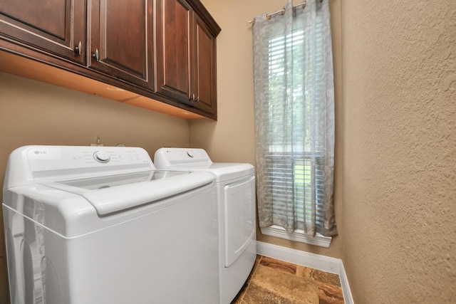 102 Stonecrop Pl, Montgomery, TX 77316 - laundry room with washing machine and clothes dryer, cabinet space, stone finish floors, and a textured wall