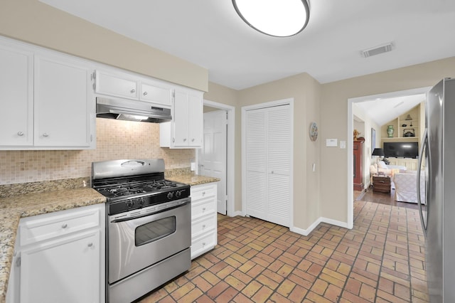 2117 Nantucket Dr, Houston, TX 77057 - kitchen with stainless steel appliances, under cabinet range hood, backsplash, white cabinets, and brick patterned floors