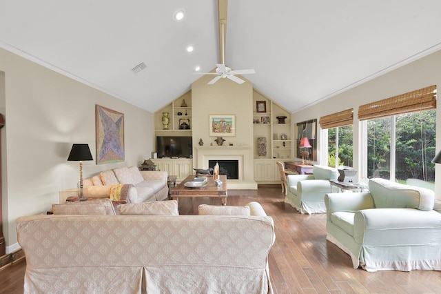 2117 Nantucket Dr, Houston, TX 77057 - living area with built in features, wood finished floors, a ceiling fan, a fireplace with raised hearth, and vaulted ceiling