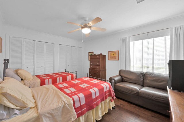 2117 Nantucket Dr, Houston, TX 77057 - bedroom with multiple closets, dark wood-style flooring, crown molding, and a ceiling fan