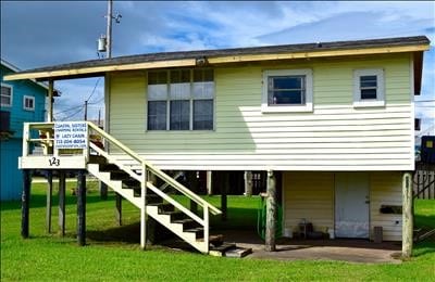 123 Sandpiper Ave, Surfside Beach, TX 77541 - rear view of property featuring stairs and a lawn