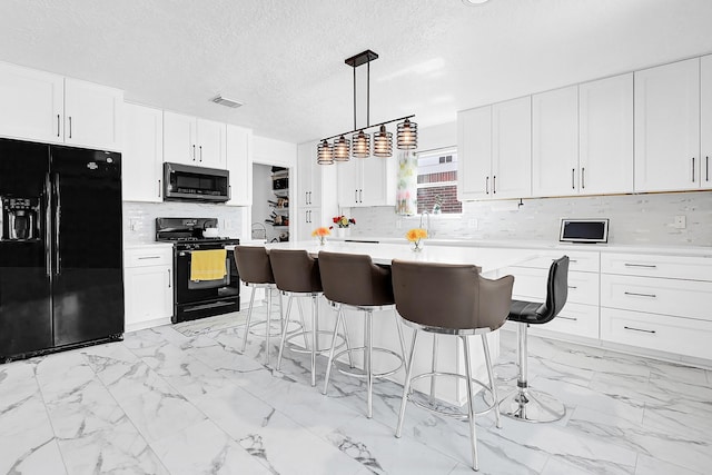 29207 Legends Hill Dr, Spring, TX 77386 - kitchen featuring black appliances, light marble finish floors, light countertops, a breakfast bar area, and decorative backsplash