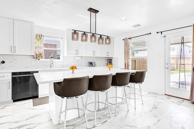 29207 Legends Hill Dr, Spring, TX 77386 - kitchen featuring dishwasher, light countertops, light marble finish floors, tasteful backsplash, and a textured ceiling
