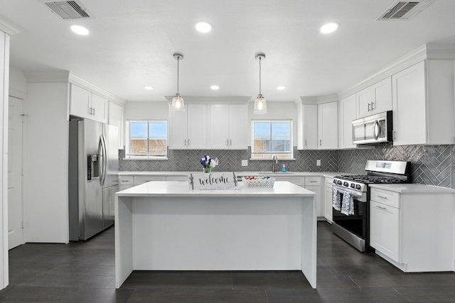 9226 Kapri Ln, Houston, TX 77025 - kitchen with stainless steel appliances, light countertops, white cabinets, backsplash, and recessed lighting