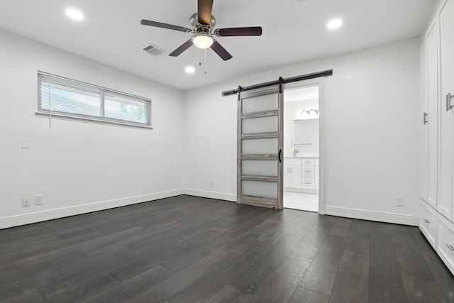 9226 Kapri Ln, Houston, TX 77025 - unfurnished bedroom with a barn door, dark wood-type flooring, recessed lighting, connected bathroom, and ceiling fan
