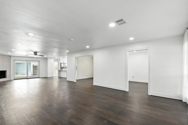 9226 Kapri Ln, Houston, TX 77025 - unfurnished living room featuring dark wood-style floors, a large fireplace, ceiling fan, and recessed lighting