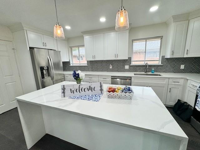 9226 Kapri Ln, Houston, TX 77025 - kitchen featuring appliances with stainless steel finishes, a center island, white cabinets, decorative backsplash, and recessed lighting