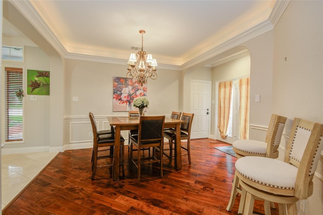 22315 Claysprings Ln, Katy, TX 77450 - dining room with arched walkways, healthy amount of natural light, a chandelier, ornamental molding, and wood finished floors