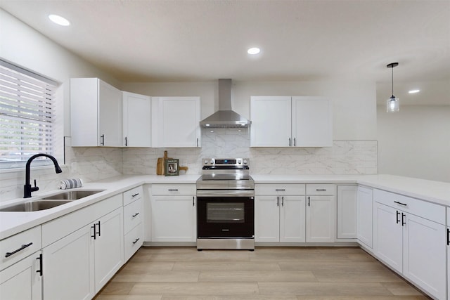 904 Dumas Dr, Bryan, TX 77803 - kitchen featuring wall chimney exhaust hood, stainless steel electric range oven, white cabinetry, light wood finished floors, and recessed lighting