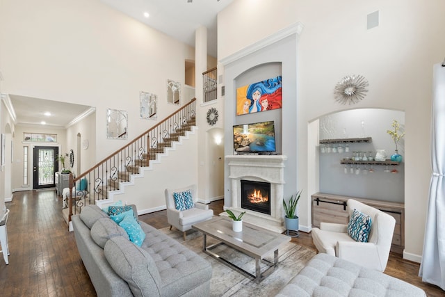9523 Sapphire Hill Ln, Katy, TX 77494 - living room with a towering ceiling, stairway, ornamental molding, a glass covered fireplace, and hardwood / wood-style flooring