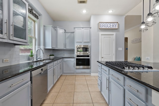 9523 Sapphire Hill Ln, Katy, TX 77494 - kitchen featuring appliances with stainless steel finishes, dark stone counters, backsplash, light tile patterned flooring, and pendant lighting